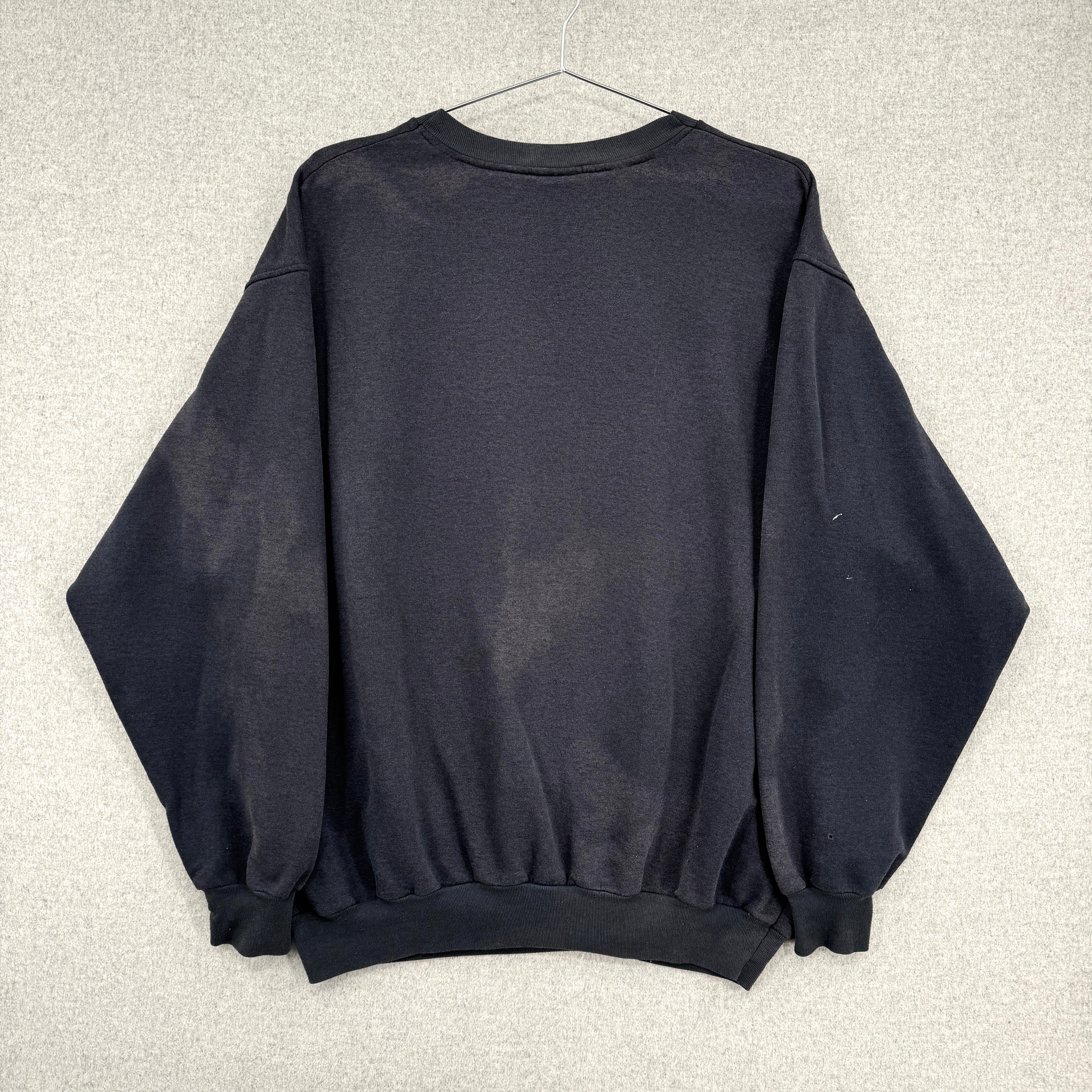 Black sweatshirt on a hanger against a neutral background. Back of sweater showing discolouration