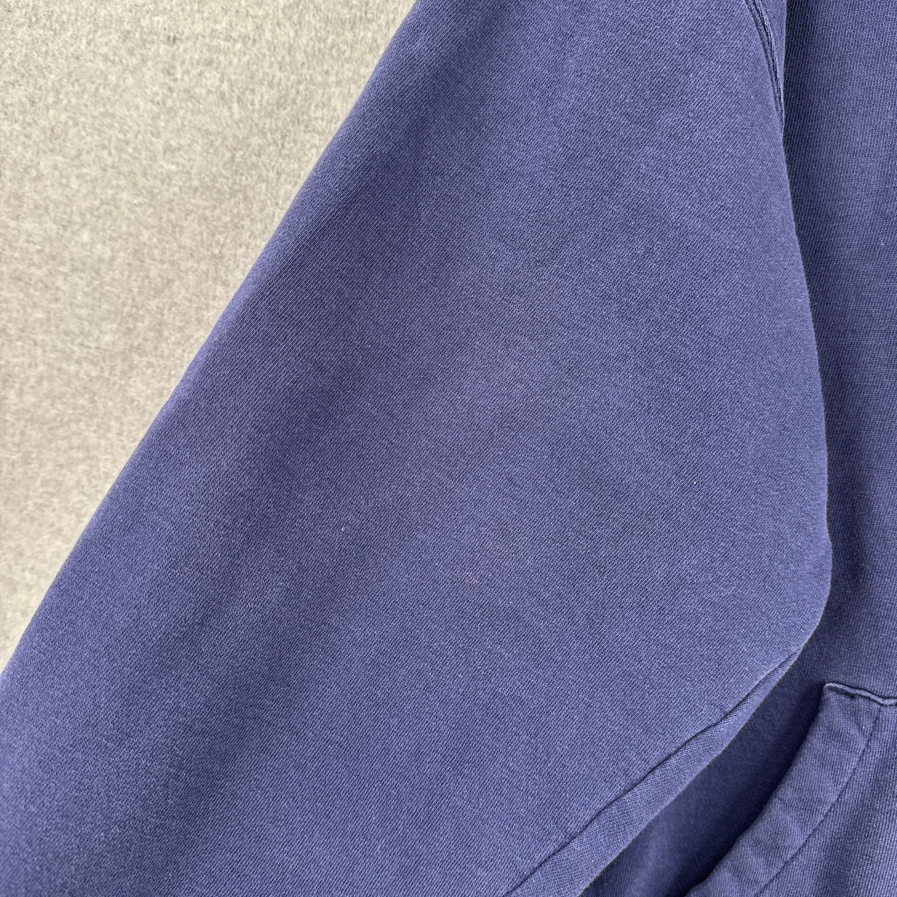 Close-up of a blue fabric texture on a neutral background. shows slight discolouration spot