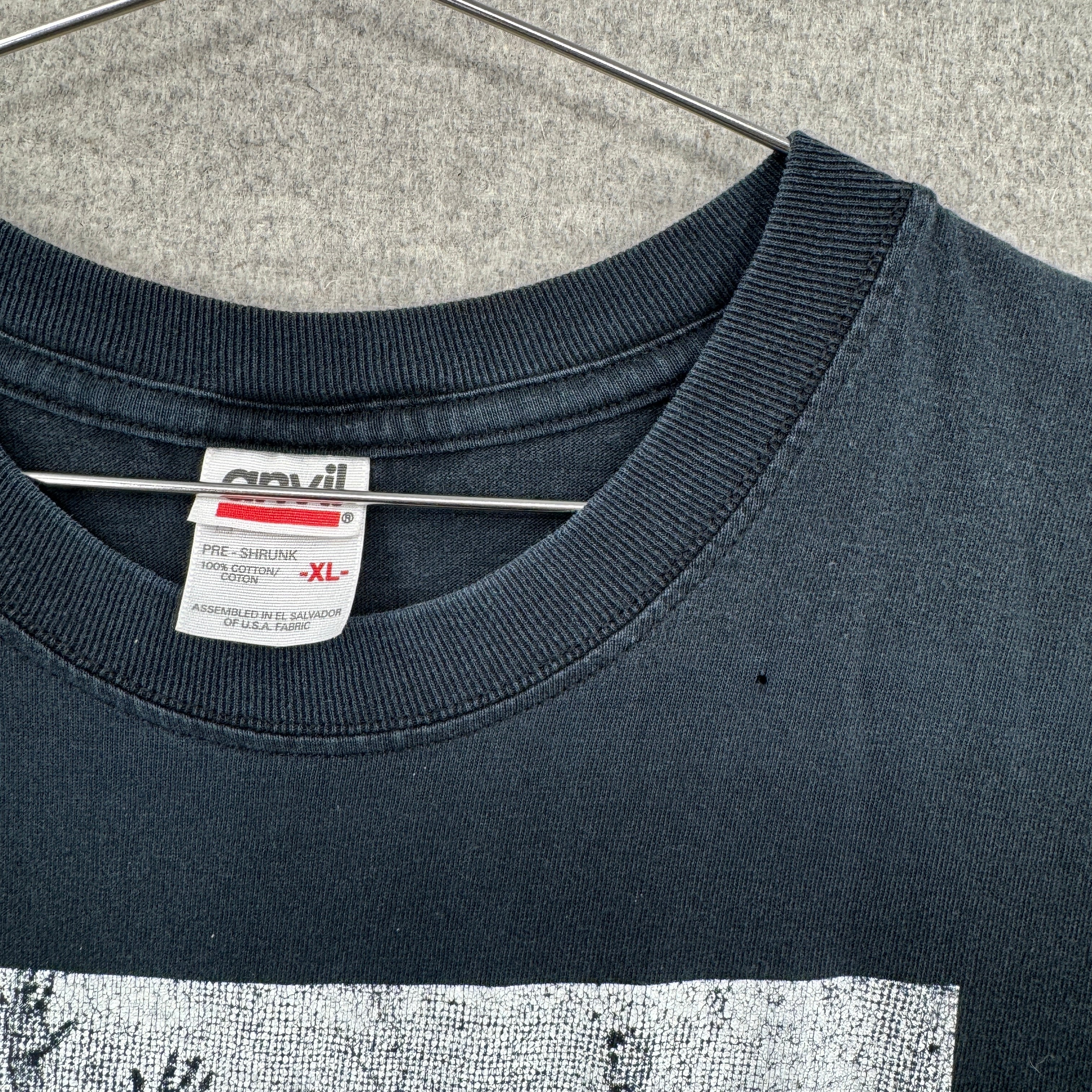 Anvil brand tag, pre shrunk 100# cotton. Size XL. near the collar of the shirt is a small hole.